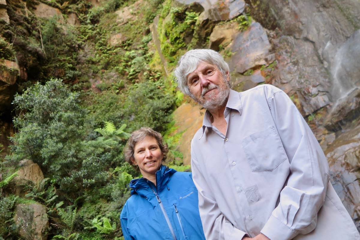 Sarah Delaney and Ian Brown with the Dwarf Mountain Pine hanging on the sandstone cliff behind them